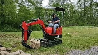 Gardner&#39;s Groundhog mini excavator testing out the rake stacking rocks.